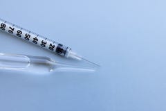 Прозрачный контейнер пробирки с жидкостной медициной около малого шприца инсулина на голубой предпосылке стоковые фотографии rf Прозрачный контейнер пробирки с жидкостной медициной около малого шприца инсулина на голубой предпосылке стоковые фотографии rf