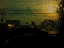 Проливной дождь и красный свет в вечере Стоковое Изображение RF Проливной дождь и красный свет в вечере Стоковое Изображение RF