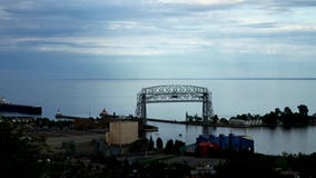 Промежуток времени корабля руды входя в гавань Дулута под мост подъема Промежуток времени корабля руды входя в гавань Дулута под мост подъема