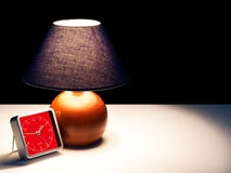 Проснитесь на ноче - лампе, свете и часах в темноте стоковое изображение Проснитесь на ноче - лампе, свете и часах в темноте стоковое изображение
