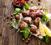 Протыкальники Kofta, фрикадельки и красный лук с добавлением свежей мяты и тимиана стоковое изображение rf Протыкальники Kofta, фрикадельки и красный лук с добавлением свежей мяты и тимиана стоковое изображение rf