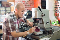 Профессиональный ключевой резец делая дверь пользуется ключом экземпляры стоковое изображение Профессиональный ключевой резец делая дверь пользуется ключом экземпляры стоковое изображение