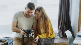 Профессиональный человек фотографа показывая фото на цифровой фотокамера к девушке студента на личных materclass в студии фото стоковая фотография rf Профессиональный человек фотографа показывая фото на цифровой фотокамера к девушке студента на личных materclass в студии фото стоковая фотография rf