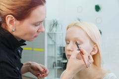 Процесс делать макияж Художник макияжа работая с щеткой на модельной стороне стоковое фото rf Процесс делать макияж Художник макияжа работая с щеткой на модельной стороне стоковое фото rf