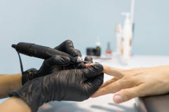 Процесс крупного плана профессионального маникюра Руки женщины Manicurist в черных перчатках делая маникюр используя профессионал стоковая фотография Процесс крупного плана профессионального маникюра Руки женщины Manicurist в черных перчатках делая маникюр используя профессионал стоковая фотография