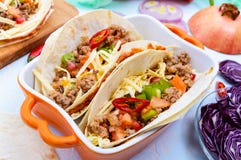 Пряные мексиканские тако с семенить мясом, помятые фасоли, овощи, заскрежетанный сыр Стоковая Фотография RF Пряные мексиканские тако с семенить мясом, помятые фасоли, овощи, заскрежетанный сыр Стоковая Фотография RF