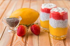 Пудинг Chia с манго, естественным йогуртом, дикой клубникой в стекле на деревянном столе Здоровый десерт, супер еда стоковые фото Пудинг Chia с манго, естественным йогуртом, дикой клубникой в стекле на деревянном столе Здоровый десерт, супер еда стоковые фото