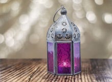 Пурпурный фонарик на деревянной поверхности Предпосылка bokeh золота с космосом экземпляра стоковые фотографии rf Пурпурный фонарик на деревянной поверхности Предпосылка bokeh золота с космосом экземпляра стоковые фотографии rf
