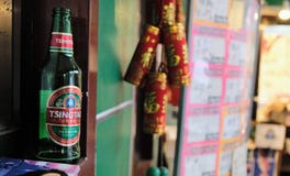 Пустая бутылка пива Tsingtao с расплывчатой строкой фейерверка в предпосылке стоковое изображение rf Пустая бутылка пива Tsingtao с расплывчатой строкой фейерверка в предпосылке стоковое изображение rf