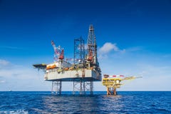 Работа буровой установки нефти и газ над удаленной нефтью и газ платформы wellhead до полного окончания производит хорошо стоковая фотография rf Работа буровой установки нефти и газ над удаленной нефтью и газ платформы wellhead до полного окончания производит хорошо стоковая фотография rf