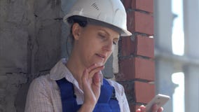 Работник молодой конструкции женский сидит на месте и работает на smartphone акции видеоматериалы Работник молодой конструкции женский сидит на месте и работает на smartphone акции видеоматериалы