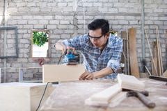 Работник на месте для работы плотника уточняя поверхность деревянной доски стоковое фото rf Работник на месте для работы плотника уточняя поверхность деревянной доски стоковое фото rf