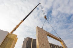 Работник построителя Roofer при кран устанавливая структурный изолированный ГЛОТОЧЕК панелей Строя дом новой рамки с низким энерг стоковые фотографии rf Работник построителя Roofer при кран устанавливая структурный изолированный ГЛОТОЧЕК панелей Строя дом новой рамки с низким энерг стоковые фотографии rf