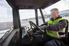 Работник управляя тележкой отбуксировки на взлётно-посадочная дорожка Стоковое Изображение Работник управляя тележкой отбуксировки на взлётно-посадочная дорожка Стоковое Изображение