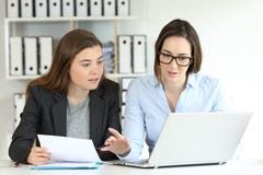 Работники офиса сравнивая на-линию документов стоковые изображения Работники офиса сравнивая на-линию документов стоковые изображения
