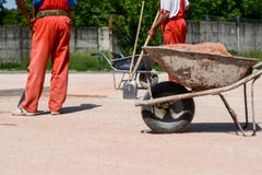 Рабочий-строители с лопаткоулавливателями Они носят красные брюки стоковое изображение Рабочий-строители с лопаткоулавливателями Они носят красные брюки стоковое изображение