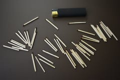 Разбросанные новые спички с черным лихтером на коричневой штейновой предпосылке стоковые фото Разбросанные новые спички с черным лихтером на коричневой штейновой предпосылке стоковые фото