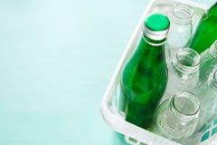 Различная стеклянная бутылка расточительствует готовое для повторно использовать в белой корзине на зеленой предпосылке Социальна стоковая фотография Различная стеклянная бутылка расточительствует готовое для повторно использовать в белой корзине на зеленой предпосылке Социальна стоковая фотография