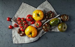 Различные типы томатов на ткани белья r стоковая фотография rf Различные типы томатов на ткани белья r стоковая фотография rf