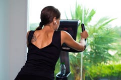 Разминка велотренажера cardio на спортзале фитнеса женщины принимая потерю веса женщина слушает музыку на наушниках o стоковая фотография Разминка велотренажера cardio на спортзале фитнеса женщины принимая потерю веса женщина слушает музыку на наушниках o стоковая фотография