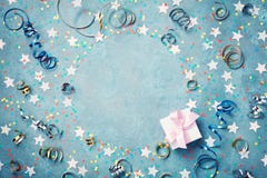 Рамка партии, масленицы или дня рождения с красочными confetti, подарочной коробкой и лентой на винтажной голубой таблице Приветс стоковые фото Рамка партии, масленицы или дня рождения с красочными confetti, подарочной коробкой и лентой на винтажной голубой таблице Приветс стоковые фото