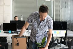 Расстроенные уволенные пожитки человека пакуя в картонной коробке стоковые изображения rf Расстроенные уволенные пожитки человека пакуя в картонной коробке стоковые изображения rf