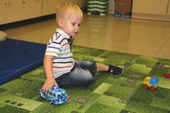 2 ребенка лет игры мальчика с автомобилями Воспитательные игрушки для preschool и ребенка детского сада, крытой спортивной площад стоковая фотография rf 2 ребенка лет игры мальчика с автомобилями Воспитательные игрушки для preschool и ребенка детского сада, крытой спортивной площад стоковая фотография rf