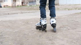 Ребенок не может пойти на грязную улицу на роликах Ребенок который учит к коньку ролика Ребенок не может пойти на грязную улицу на роликах Ребенок который учит к коньку ролика