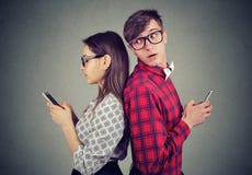 Ревнивый человек рассматривая его плечо на его телефоне подруги пробуя увидеть что она отправляет СМС стоковое изображение rf Ревнивый человек рассматривая его плечо на его телефоне подруги пробуя увидеть что она отправляет СМС стоковое изображение rf