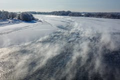 Река зимы ландшафта замерзает с заморозком, подъемами пара над рекой на солнечный день стоковое изображение rf Река зимы ландшафта замерзает с заморозком, подъемами пара над рекой на солнечный день стоковое изображение rf