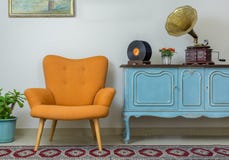 Ретро оранжевое кресло и винтажный деревянный свет - голубой sideboard стоковые фотографии rf Ретро оранжевое кресло и винтажный деревянный свет - голубой sideboard стоковые фотографии rf