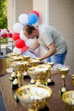 Рефери подготавливает сертификаты и чашки спорт для награждать спортсменов вертикально стоковые фото Рефери подготавливает сертификаты и чашки спорт для награждать спортсменов вертикально стоковые фото