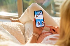 Рига, Латвия - 21-ое июля 2018: Женщина смотря приложение QQ на мобильном телефоне стоковые фотографии rf Рига, Латвия - 21-ое июля 2018: Женщина смотря приложение QQ на мобильном телефоне стоковые фотографии rf