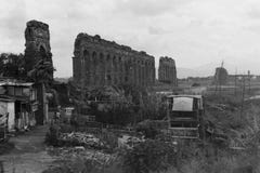 РИМ, ИТАЛИЯ, 1966 - руины римского акведука домашние к некоторым плохим казармам стоковые изображения rf РИМ, ИТАЛИЯ, 1966 - руины римского акведука домашние к некоторым плохим казармам стоковые изображения rf