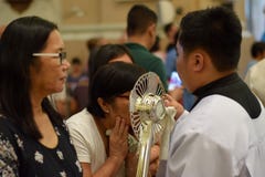 Римско-католическим женщинам дают редкий шанс целуя святого Monstrance во время праздненства городка стоковая фотография rf Римско-католическим женщинам дают редкий шанс целуя святого Monstrance во время праздненства городка стоковая фотография rf