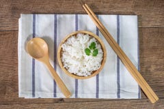 Рис жасмина белый, сваренный белый рис, сварил простой рис в деревянном шаре с ложкой и палочками, органическим рисом на деревенс стоковые фотографии rf Рис жасмина белый, сваренный белый рис, сварил простой рис в деревянном шаре с ложкой и палочками, органическим рисом на деревенс стоковые фотографии rf