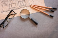 Рисующ со стеклами, карандашами и лупой на конкретной таблице стоковое изображение rf Рисующ со стеклами, карандашами и лупой на конкретной таблице стоковое изображение rf