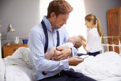 Родители при молодой младенец одевая для работы в спальне стоковые фотографии rf Родители при молодой младенец одевая для работы в спальне стоковые фотографии rf