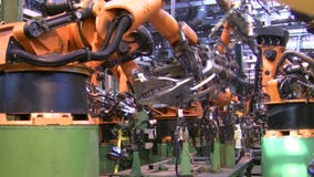 Роботы сваривают части автомобиля в производственной линии на фабрике Роботы сваривают части автомобиля в производственной линии на фабрике