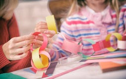 Рождество: Работа родителя и ребенка на бумажной цепной гирлянде стоковые изображения Рождество: Работа родителя и ребенка на бумажной цепной гирлянде стоковые изображения