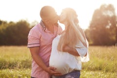 Романтичный портрет будущих родителей целует и выражает влюбленность Ласковый супруг держит руку на tummy его беременной жены, to стоковые фото Романтичный портрет будущих родителей целует и выражает влюбленность Ласковый супруг держит руку на tummy его беременной жены, to стоковые фото