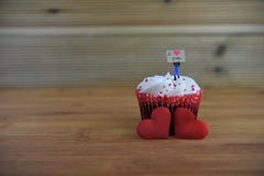 Романтичный торт чашки в красной и белом при миниатюрный figurine персоны держа доску знака на верхней части и красных сердцах вл Стоковые Фото Романтичный торт чашки в красной и белом при миниатюрный figurine персоны держа доску знака на верхней части и красных сердцах вл Стоковые Фото