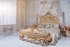 Роскошная спальня в светлых цветах с золотыми деталями мебели Большая удобная двойная королевская кровать в элегантной классике стоковые фото Роскошная спальня в светлых цветах с золотыми деталями мебели Большая удобная двойная королевская кровать в элегантной классике стоковые фото