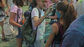 РОССИЯ, ИРКУТСК - 27-ОЕ ИЮНЯ 2018: Счастливое молодые люди танцуя и празднуя во время фестиваля Holi цветов Толпа РОССИЯ, ИРКУТСК - 27-ОЕ ИЮНЯ 2018: Счастливое молодые люди танцуя и празднуя во время фестиваля Holi цветов Толпа