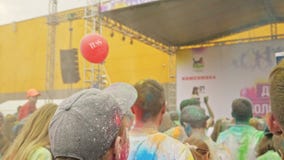 РОССИЯ, ИРКУТСК - 27-ОЕ ИЮНЯ 2018: Счастливое молодые люди танцуя и празднуя во время фестиваля Holi цветов Толпа РОССИЯ, ИРКУТСК - 27-ОЕ ИЮНЯ 2018: Счастливое молодые люди танцуя и празднуя во время фестиваля Holi цветов Толпа