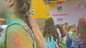 РОССИЯ, ИРКУТСК - 27-ОЕ ИЮНЯ 2018: Счастливое молодые люди танцуя и празднуя во время фестиваля Holi цветов Толпа РОССИЯ, ИРКУТСК - 27-ОЕ ИЮНЯ 2018: Счастливое молодые люди танцуя и празднуя во время фестиваля Holi цветов Толпа