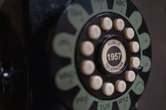 Роторный старого телефона в телефонной будке стоковое изображение Роторный старого телефона в телефонной будке стоковое изображение