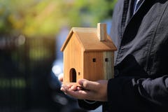 Рука бизнесмена держа модельный дом на естественной зеленой концепции предпосылки, свойства недвижимости и владения стоковые изображения rf Рука бизнесмена держа модельный дом на естественной зеленой концепции предпосылки, свойства недвижимости и владения стоковые изображения rf