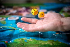 Рука бросает 2 желтых кости на игровой площадке Моменты игры в динамике Везение и ободрение r стоковое изображение rf Рука бросает 2 желтых кости на игровой площадке Моменты игры в динамике Везение и ободрение r стоковое изображение rf
