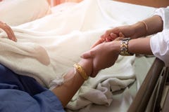 Рука девушки удерживания женщины которая пациенты лихорадки в больнице стоковая фотография rf Рука девушки удерживания женщины которая пациенты лихорадки в больнице стоковая фотография rf